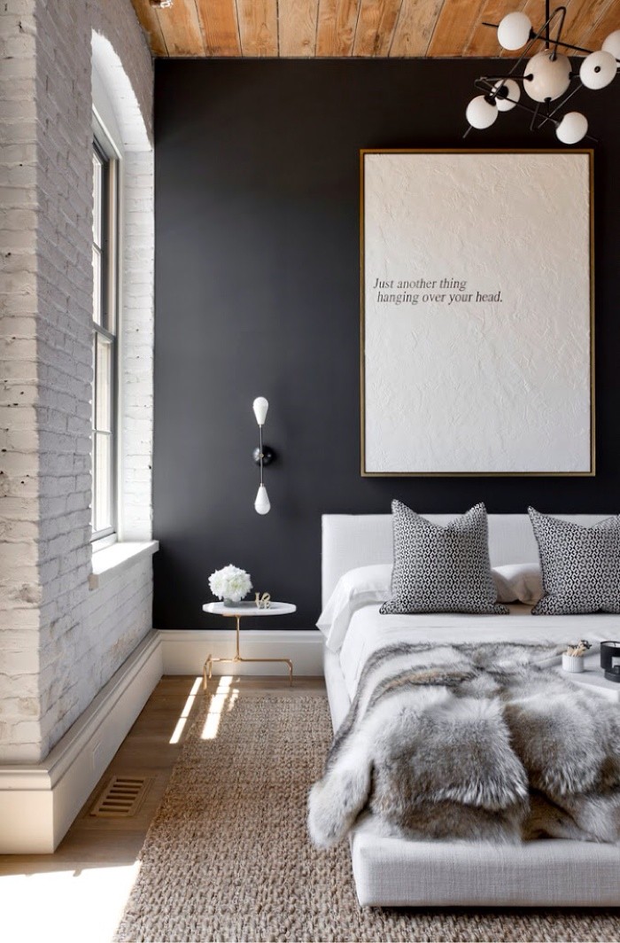 vit tegelsten och svart accentvägg i sovrummet
