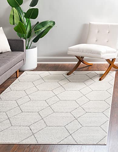 White geometric carpet in a cozy living room with a gray sofa, white chair and potted plant.