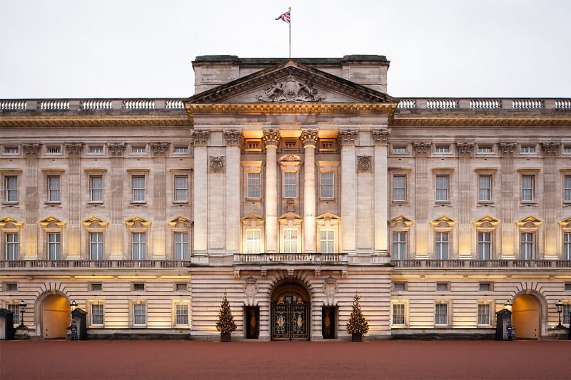 Buckingham Palace in London with an illuminated facade and central entrance.