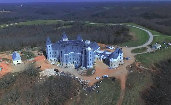 Pensmore Manor in Missouri, a castle-like estate surrounded by open fields and forest.