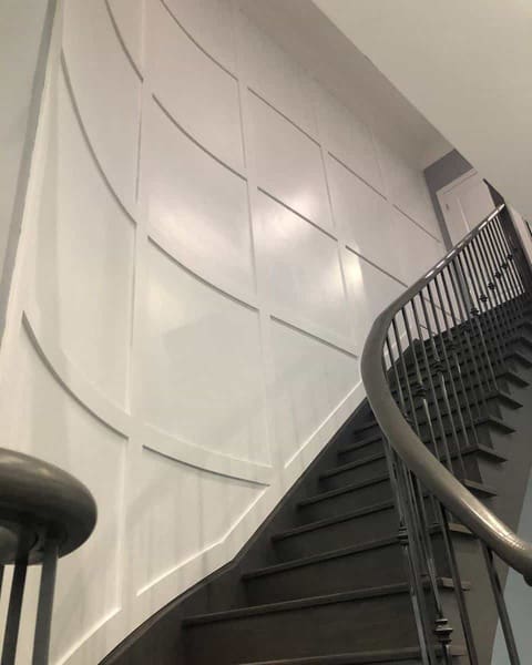 black staircase with white wainscoting