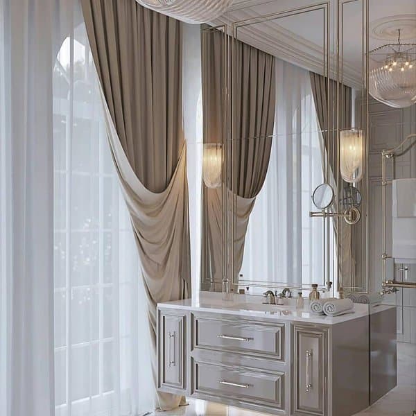 Elegant bathroom with draped curtains, mirrored walls, and polished vanity.