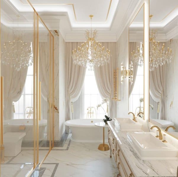 Elegant bathroom with gold accents, marble countertops, crystal chandeliers, and soft drapes.