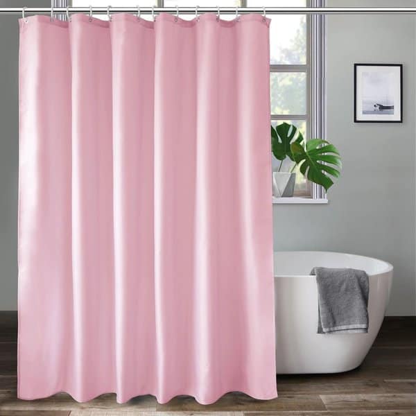 Bathroom with solid pink shower curtain, freestanding tub, and potted plant by the window.