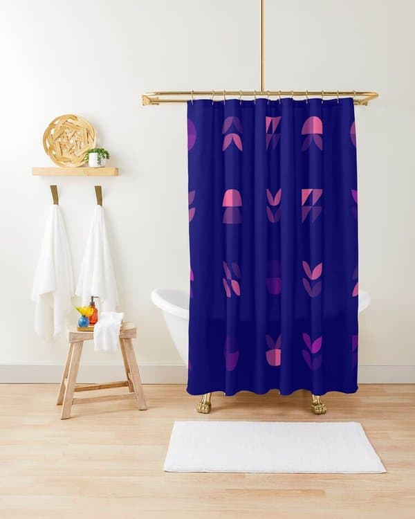 Dark blue shower curtain with abstract pink patterns in a modern bathroom with a clawfoot tub.