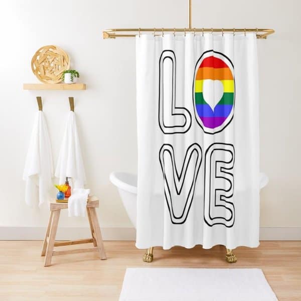 Shower curtain with "LOVE" text and rainbow heart design in a minimalist bathroom with gold accents.