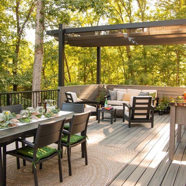 Stylish elevated deck with a modern pergola, dining area, cozy seating, and lush forest views creating a serene outdoor retreat