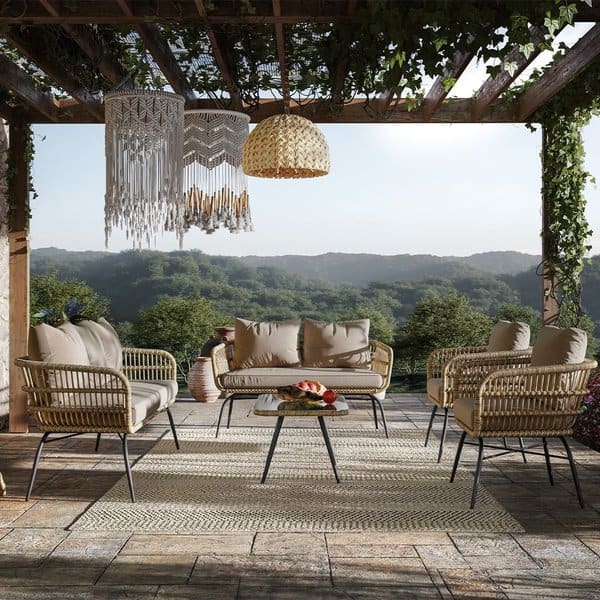 Boho-chic outdoor living area featuring wicker furniture, macramé accents, a woven pendant light, and a breathtaking view of lush green hills, perfect for a serene retreat.