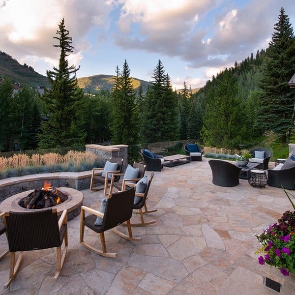 Spacious mountain patio with a firepit surrounded by cozy chairs, offering breathtaking forest views for ultimate relaxation