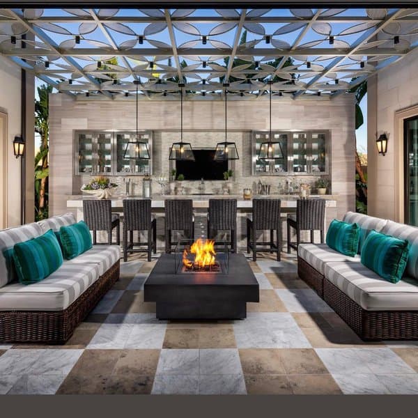 Elegant outdoor living area with modern firepit, cushioned sofas, dining bar, and stylish pergola ceiling design