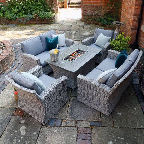 Outdoor patio with gray wicker furniture and a central fire pit table