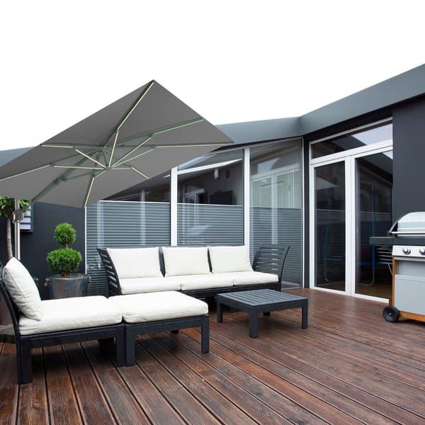 Contemporary patio setup with sleek black furniture, white cushions, and a stylish umbrella on a wooden deck